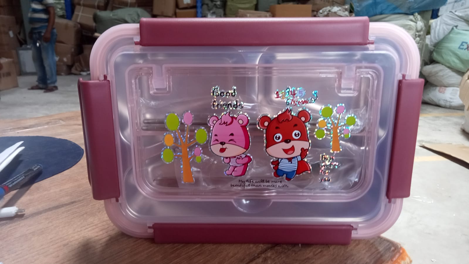 Stainless steel lunch box with compartments and utensils, ideal for school or camping.